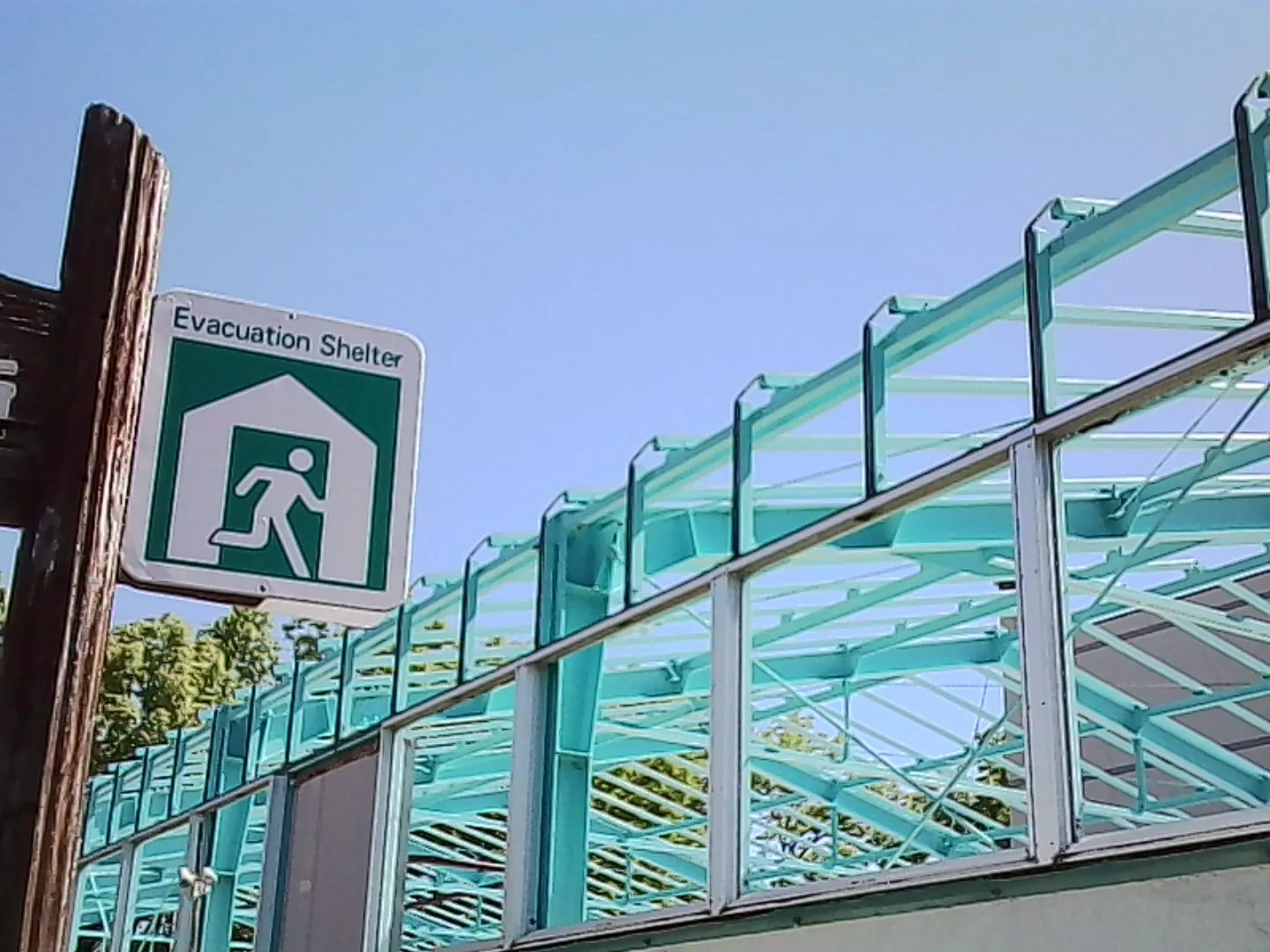 避難場所の看板と学校のプールの屋根